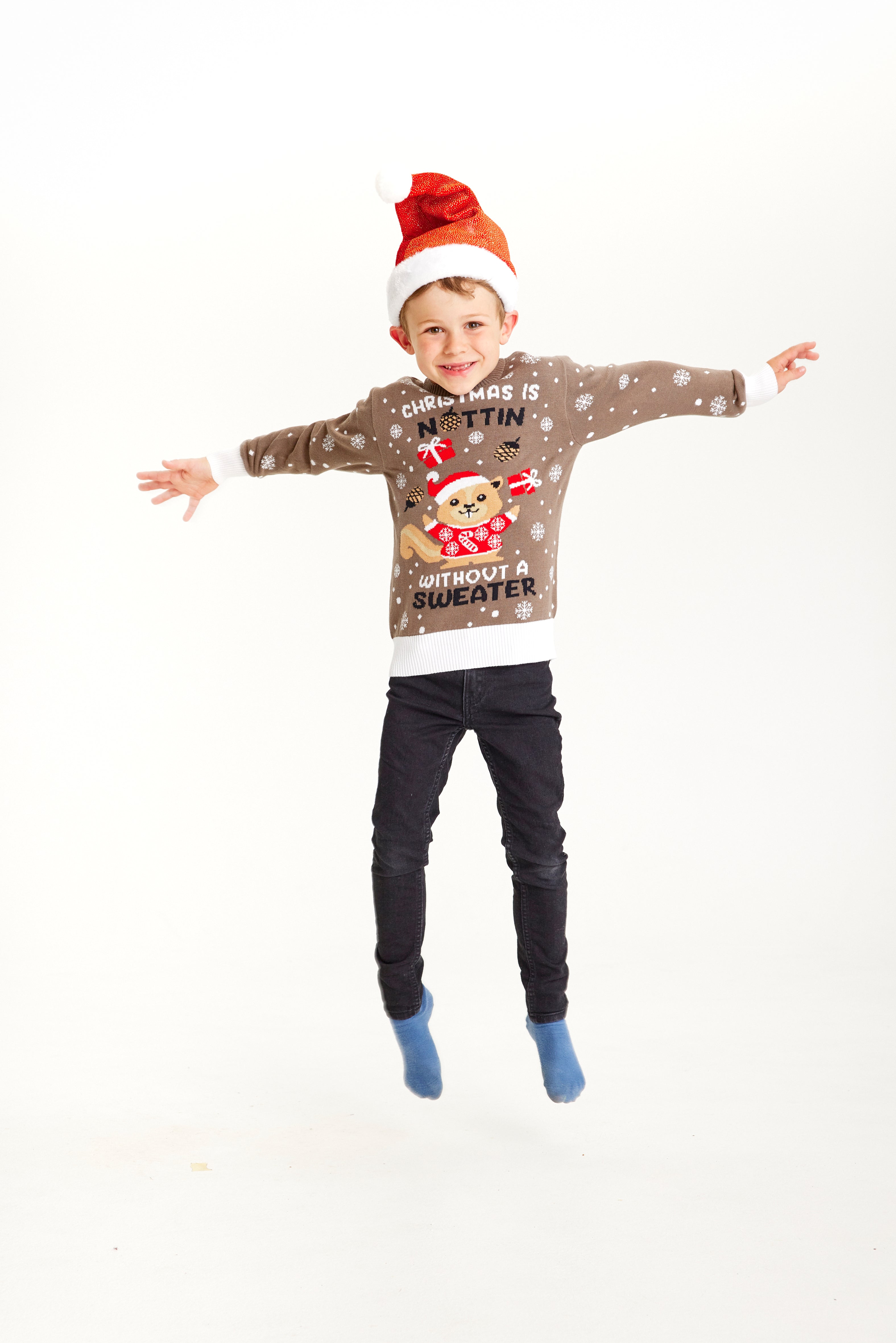 Een stuiterend kind dat een bruine kersttrui draagt met de quote 