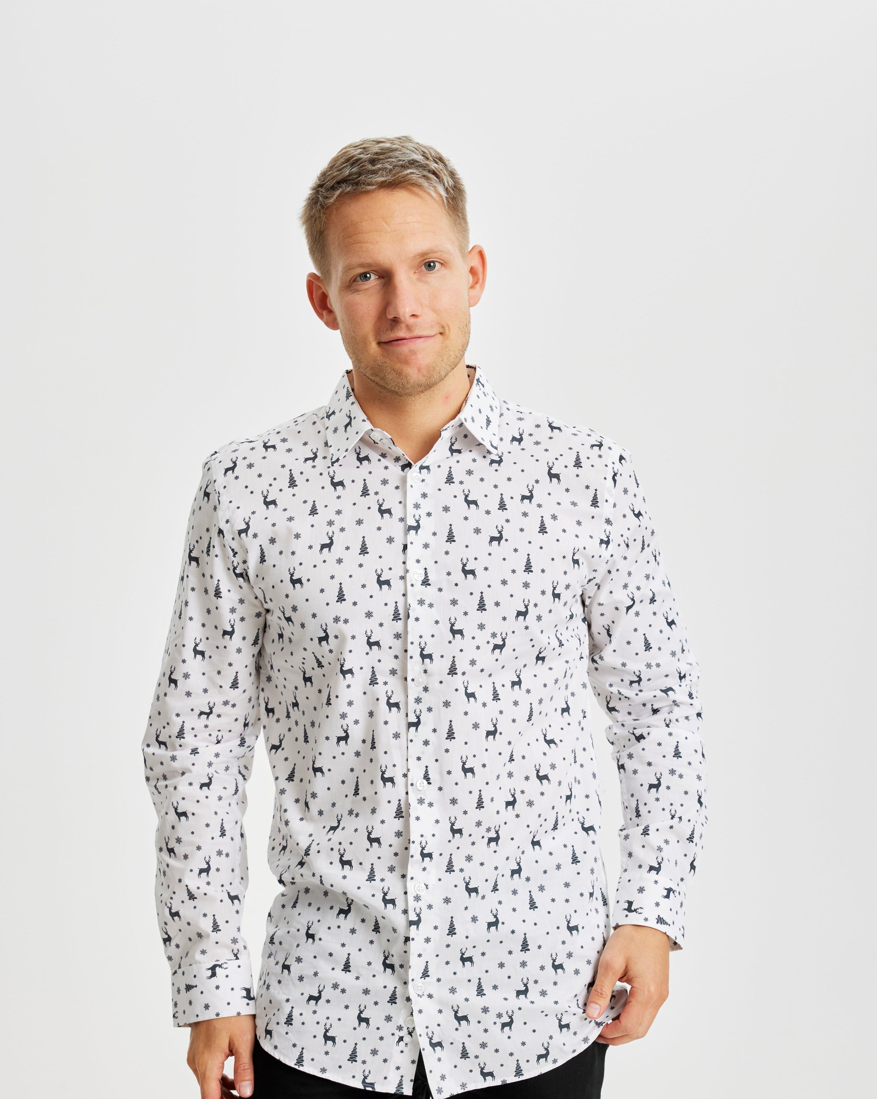 Een lachende man met een wit kerstoverhemd.