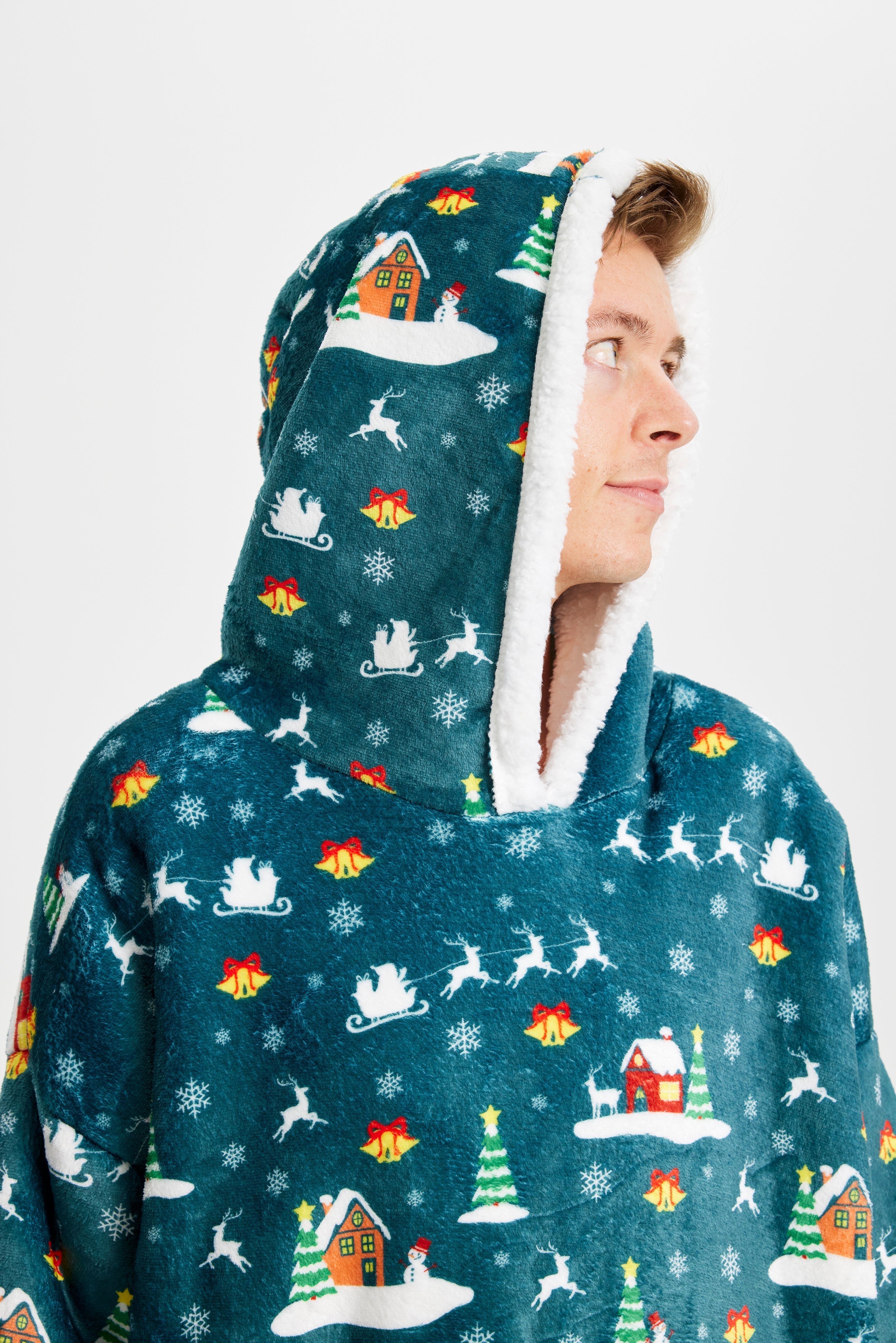 Een man die opzij kijkt en een groene kerstmuts draagt.