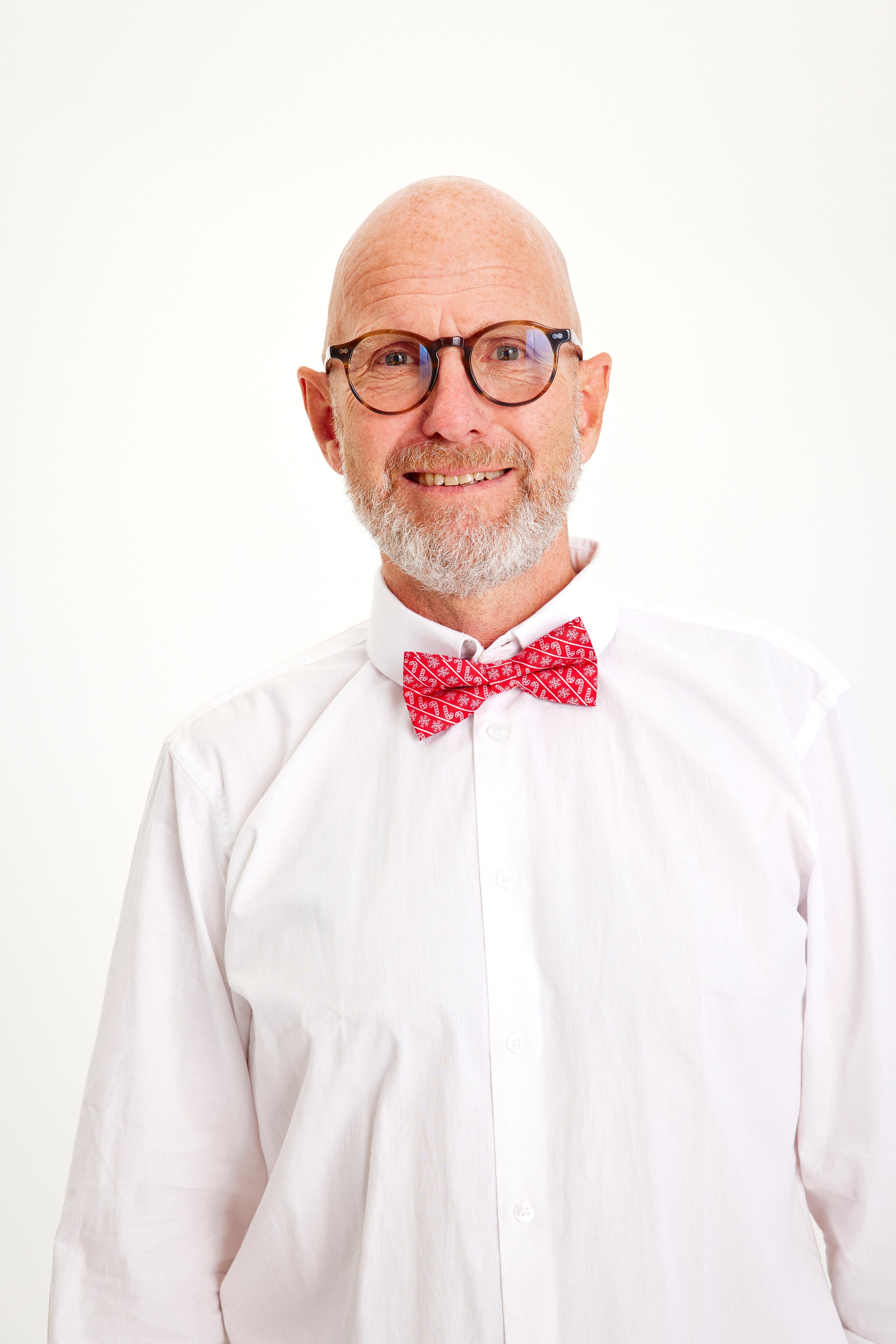 Een lachende man met een rood strikje.