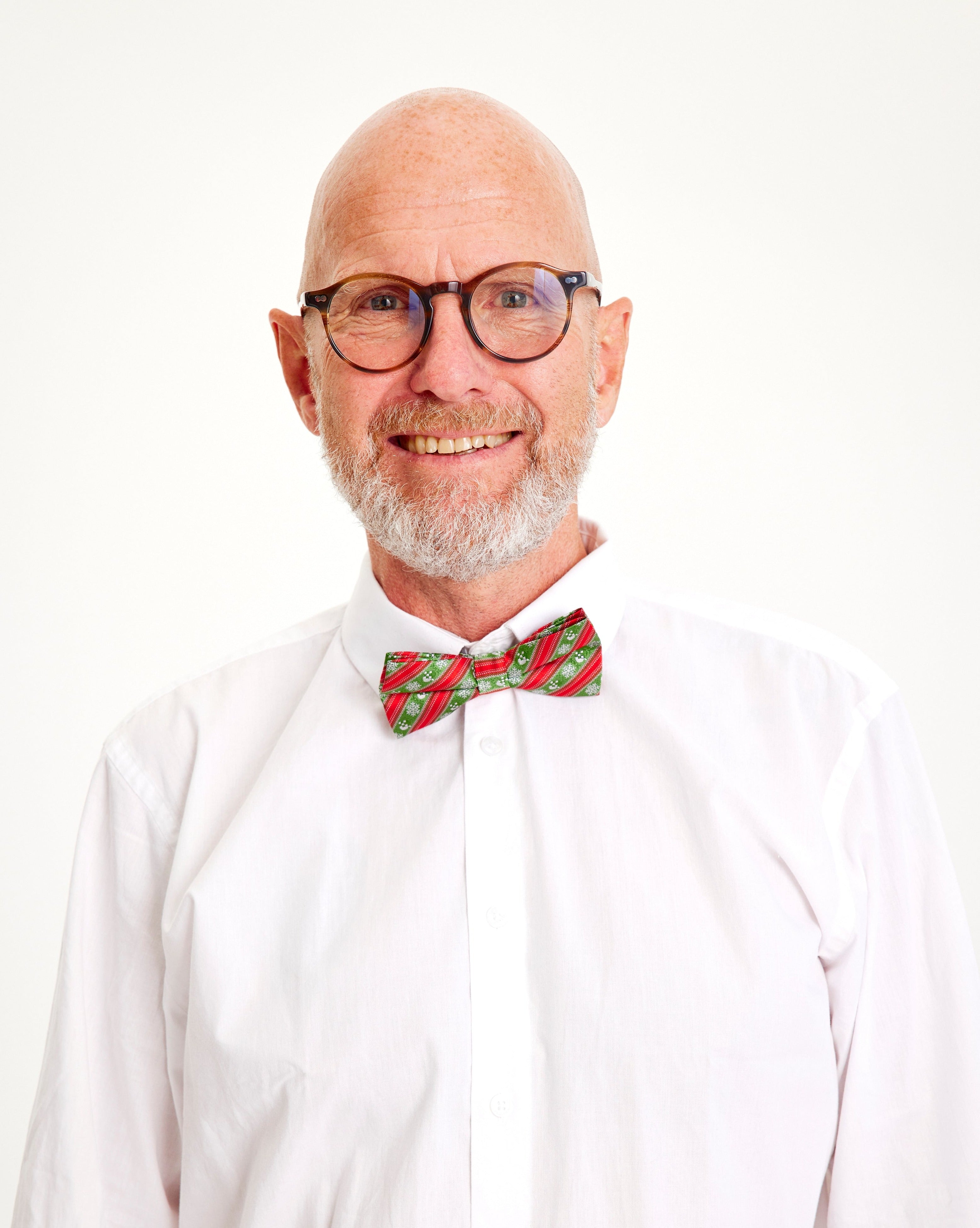 Een lachende man met een rood strikje.