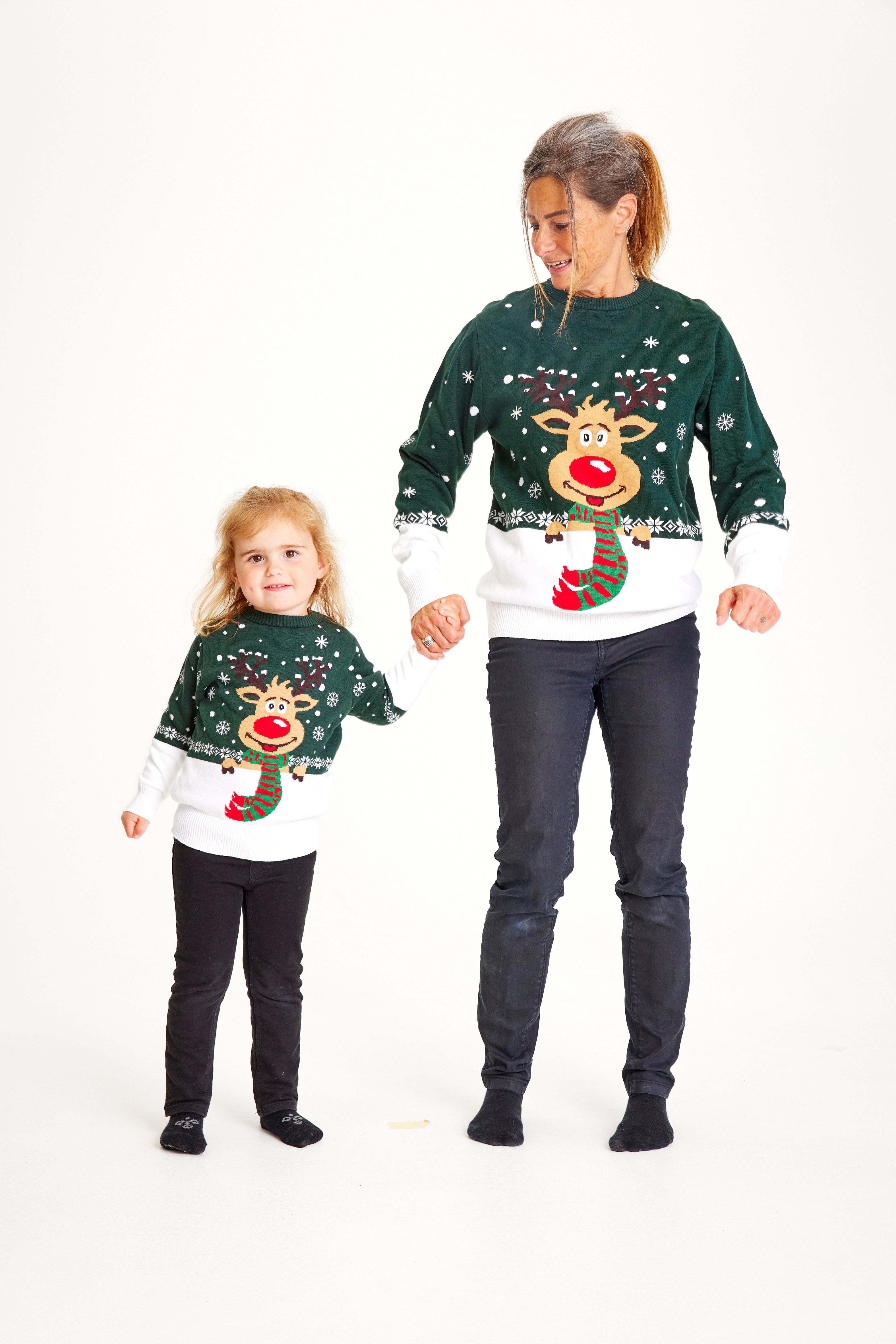 En dame og et barn grønne julesweatre med Rudolf og snefnug på.