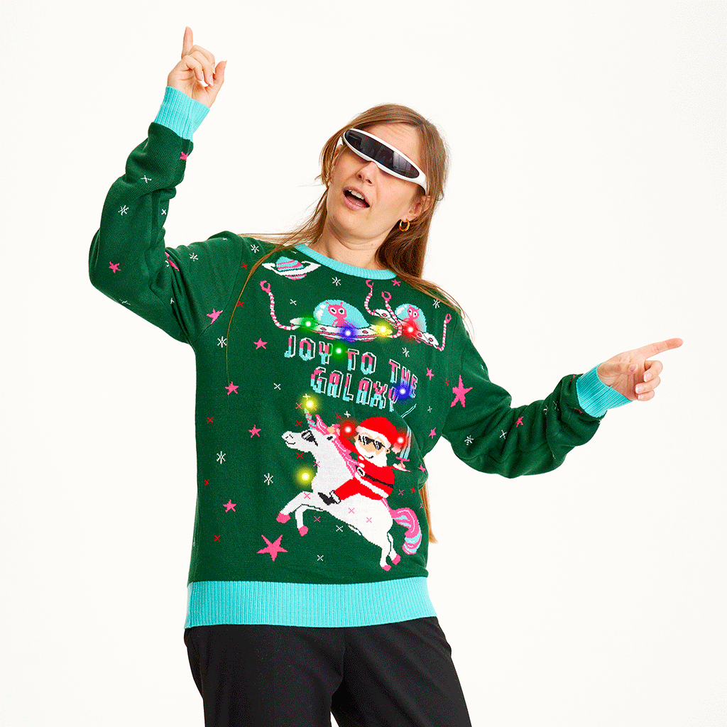 Een poserende vrouw draagt een groene kersttrui met de quote 