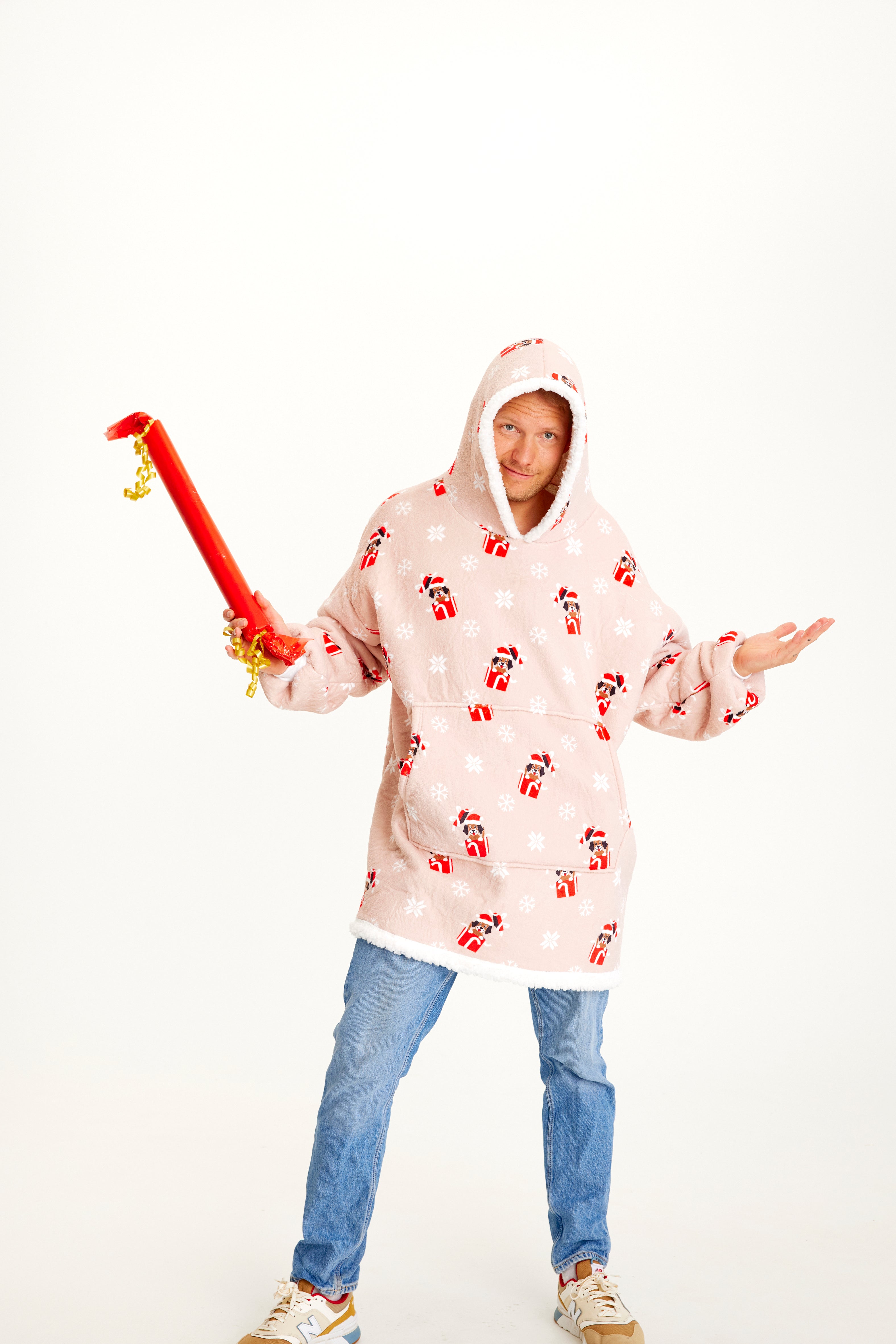 Een man draagt een roze kerst hoodie met honden erop.