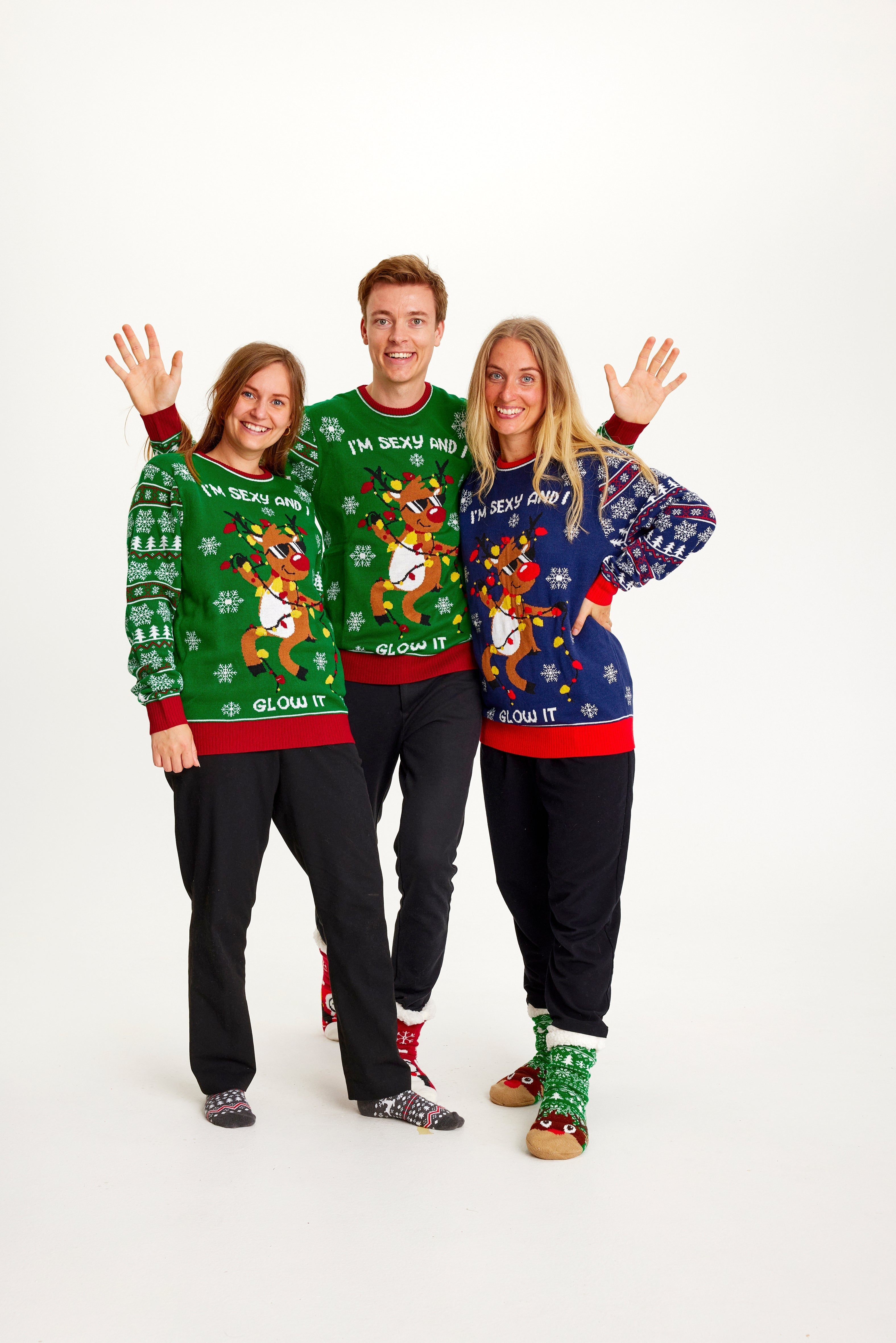 Drie mensen die een kersttrui dragen met de quote 