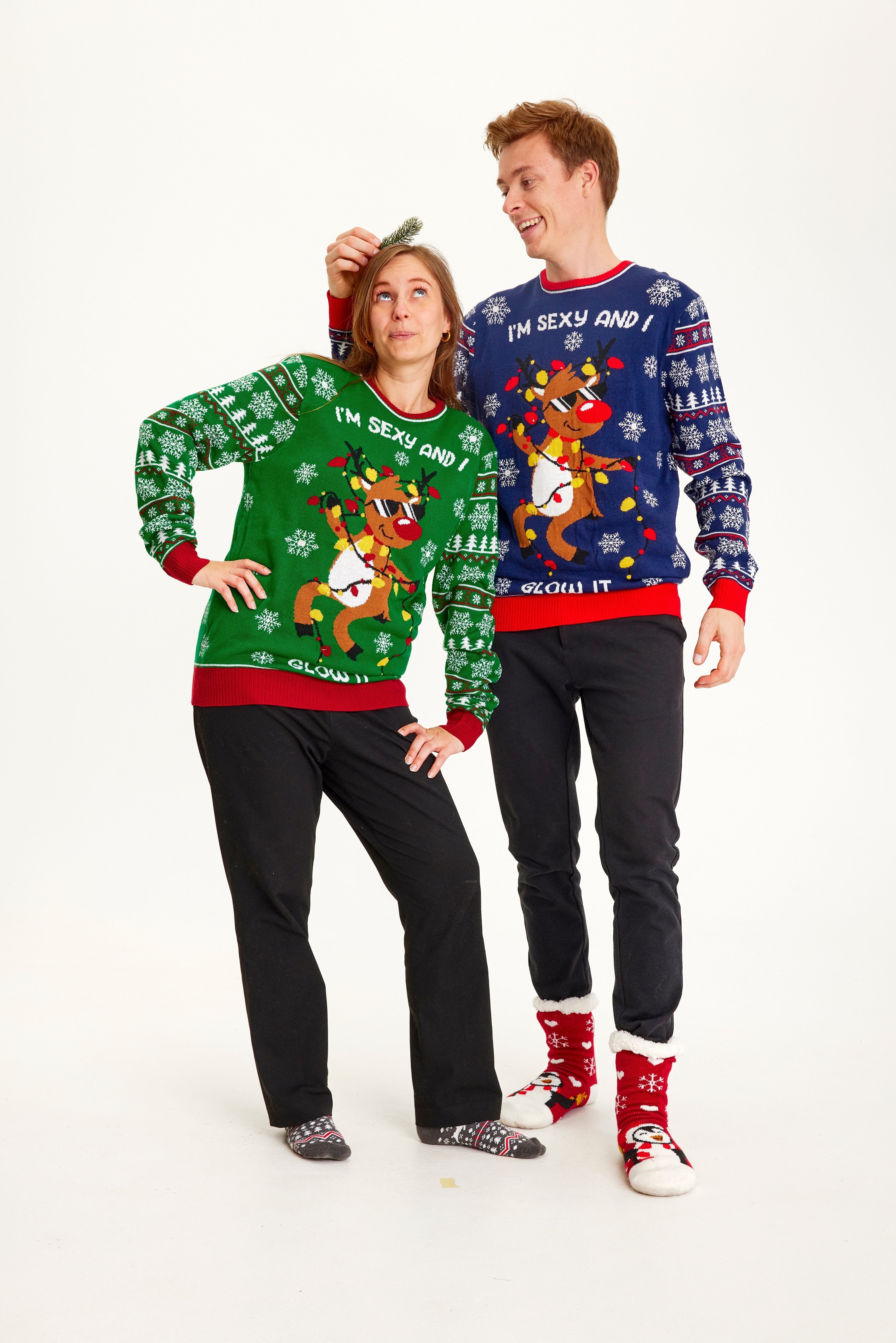 Een stel dat een kersttrui draagt met de quote 